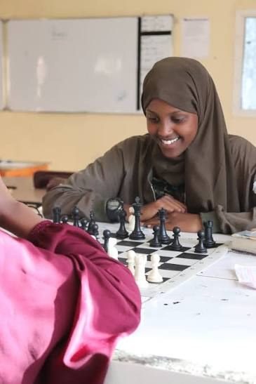 An Abaarso student smiling over a game of chess.